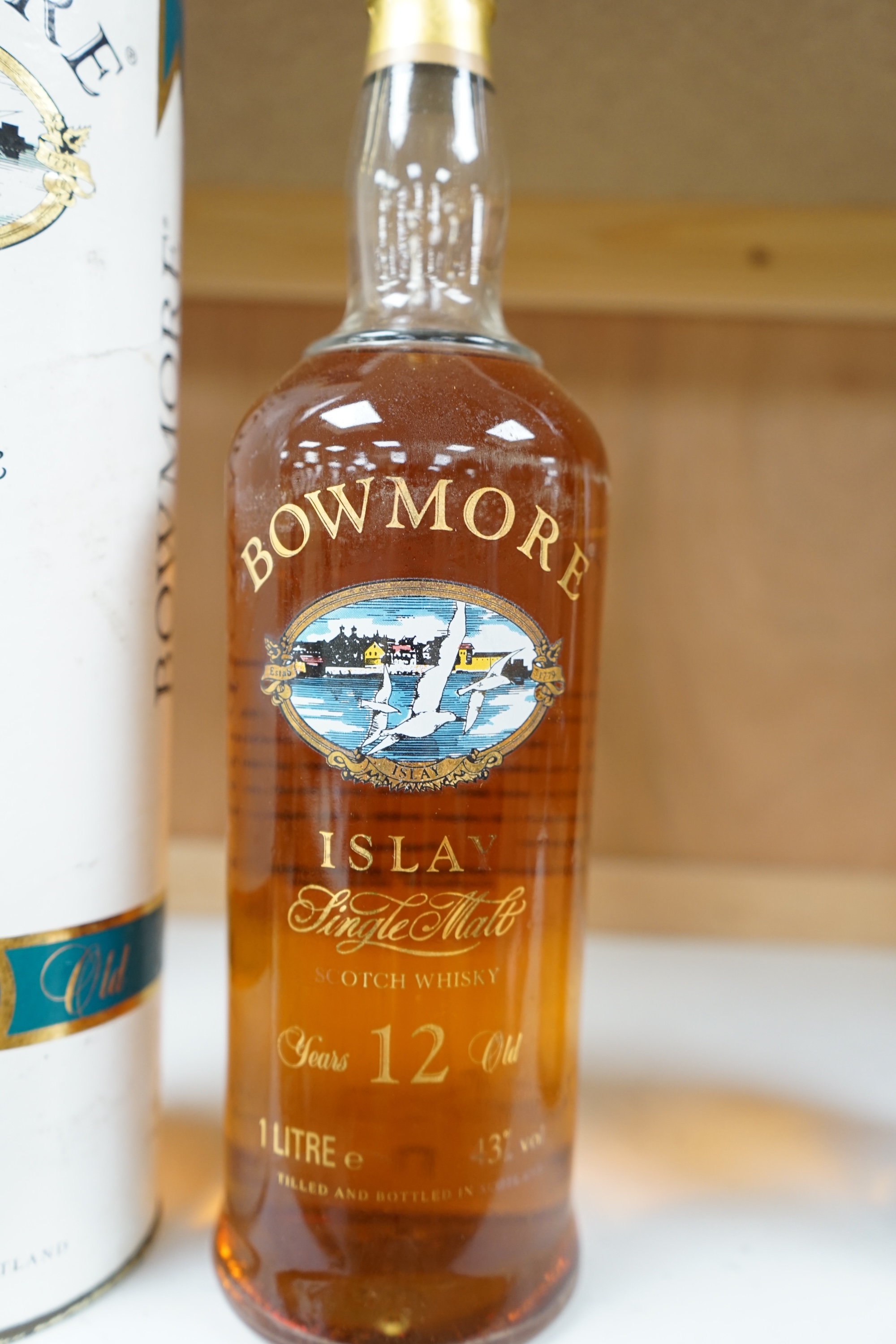 A bottle of Bowmore 12 Year Old Islay Single Malt Scotch Whisky, 1980s screen print bottle, 43% vol 1 litre, in original cardboard tube. Condition - good.